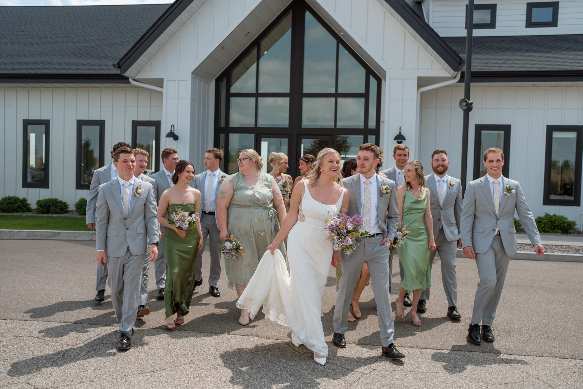 Full wedding party walking together outside of Minnesota wedding venue Woodhaven Wedding & Events in Cannon Falls in Minnesota.