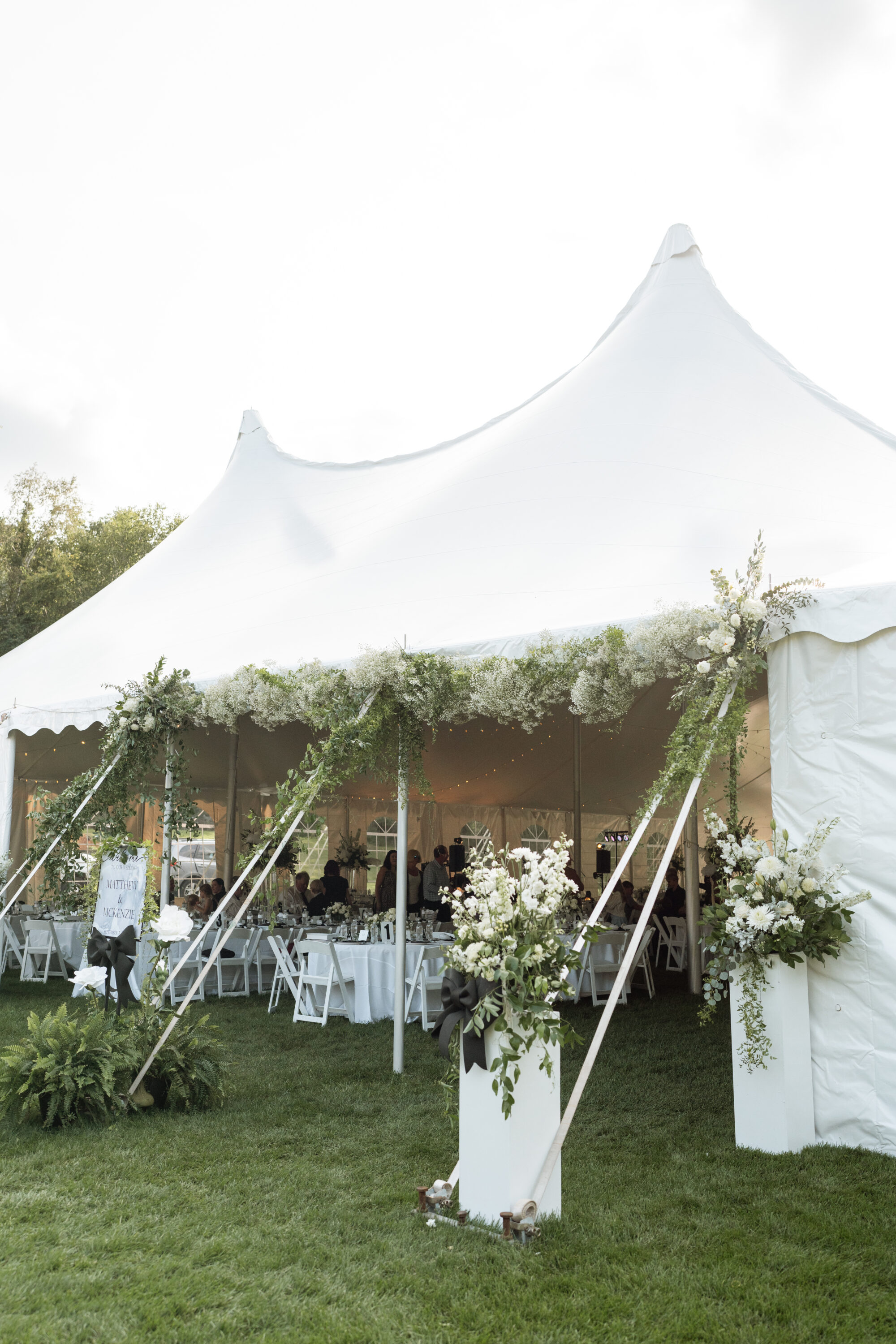 Wedding tent decorated with lots of greenery and florals at a backyard wedding in Minnesota.